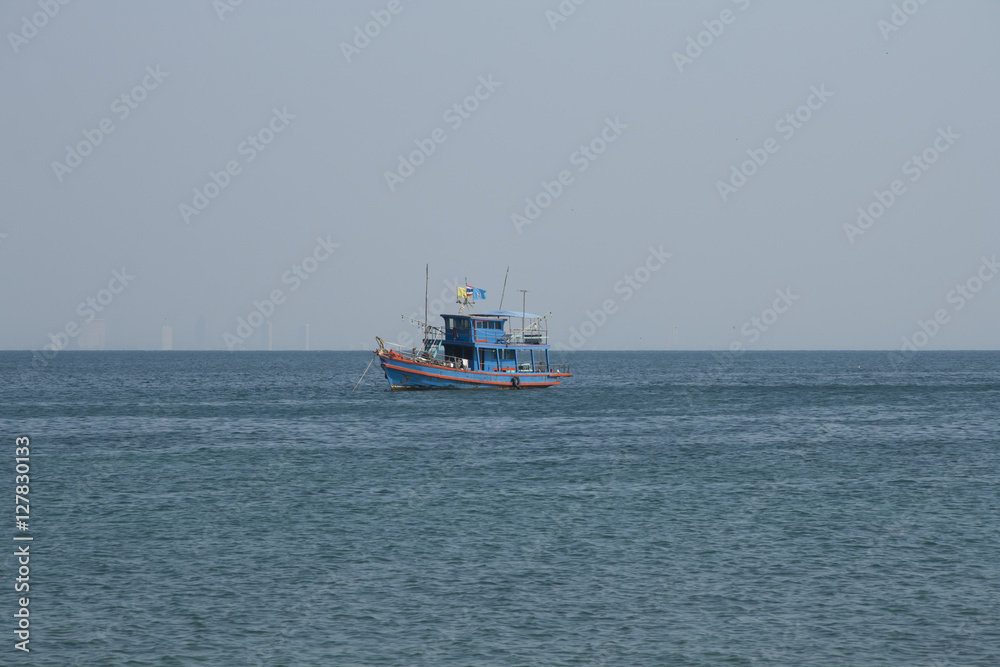 Thai fish boat in the sea with skyscrapers of Pattaya as a background