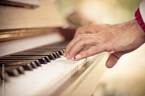 Close up man hand musician playing piano vintage tone.