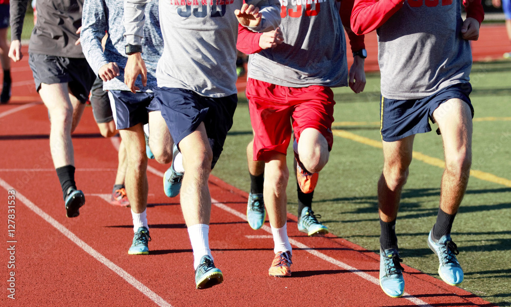 Fototapeta premium Runners group training on a red track
