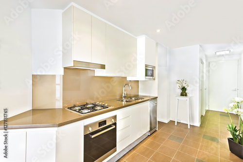 White luxury kitchen view with tools and flowers.