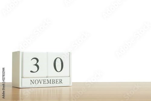 Closeup surface white wooden calendar with black 30 november word on blurred brown wood desk isolated on white background with copy space , selective focus at the calendar