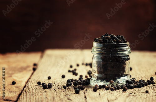 Black pepper, old wooden background, selective focus