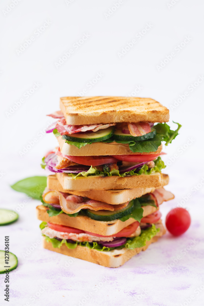 Club sandwich with chicken breast, bacon, tomato, cucumber and herbs Club sandwich with chicken breast, bacon, tomato, cucumber and herbs