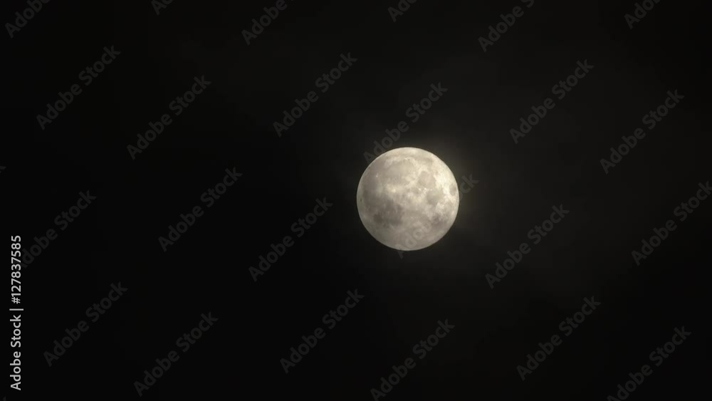 Real time clouds passing and swallowing up the full harvest moon at night. Real time clouds passing and swallowing up the full harvest moon at night.