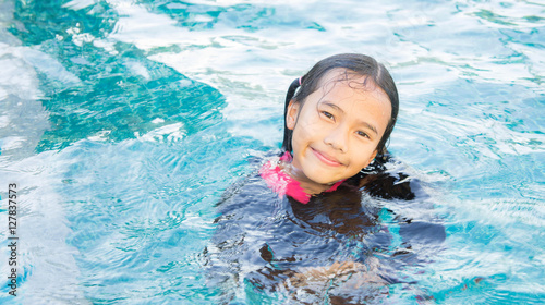 The baby girl asian enjoy swiming , kid girl playing swiming , y