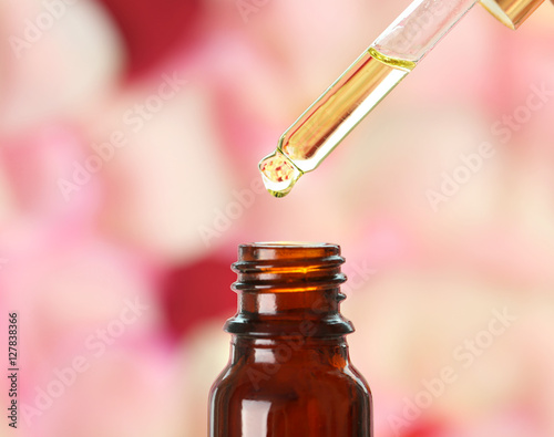Pipette with aroma oil and bottle on blurred background