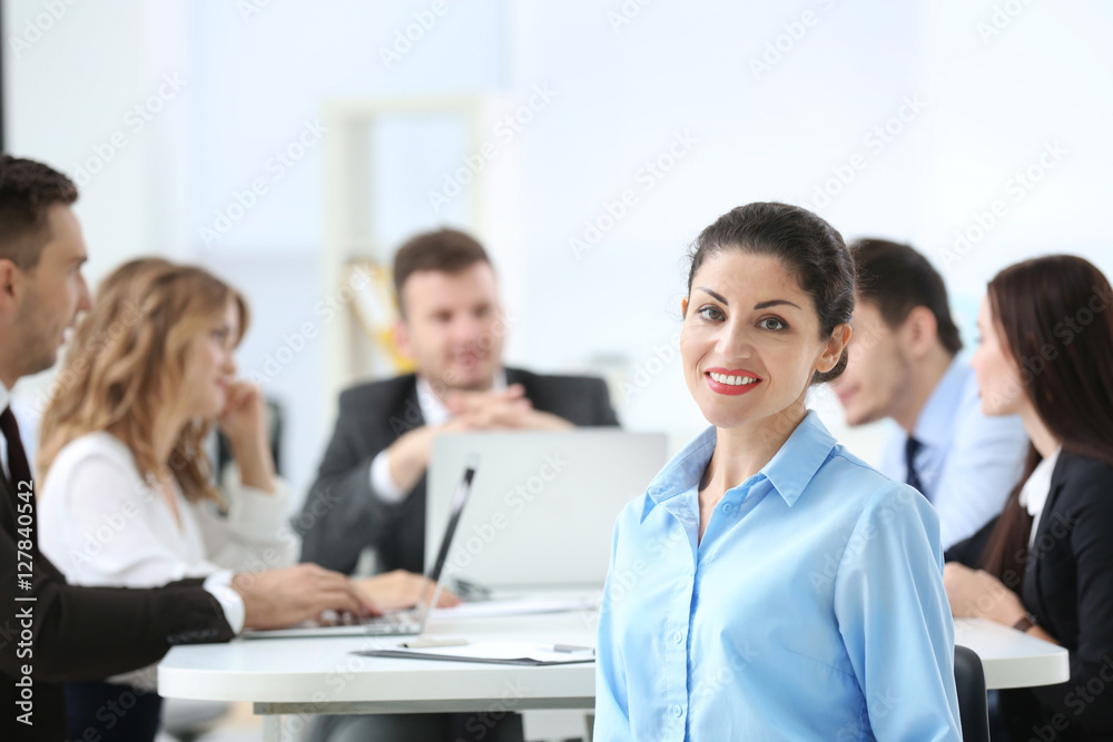 Businesswoman with colleagues on background at office Businesswoman with colleagues on background at office