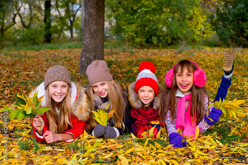 group of girls in autumn park with leafs