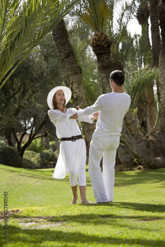 couple riant en dansant dans l'herbe photo