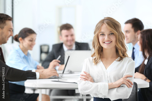 Businesswoman with colleagues on background at office