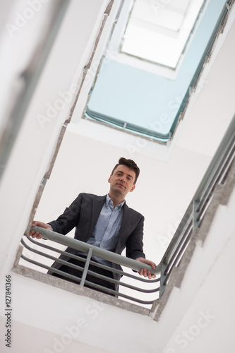 Confident businessman standing on office stairwell