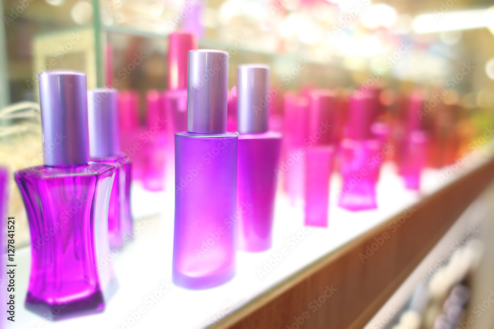 Stand with colourful glass bottles in cosmetic store Stand with colourful glass bottles in cosmetic store