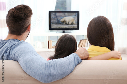 Family watching TV on couch