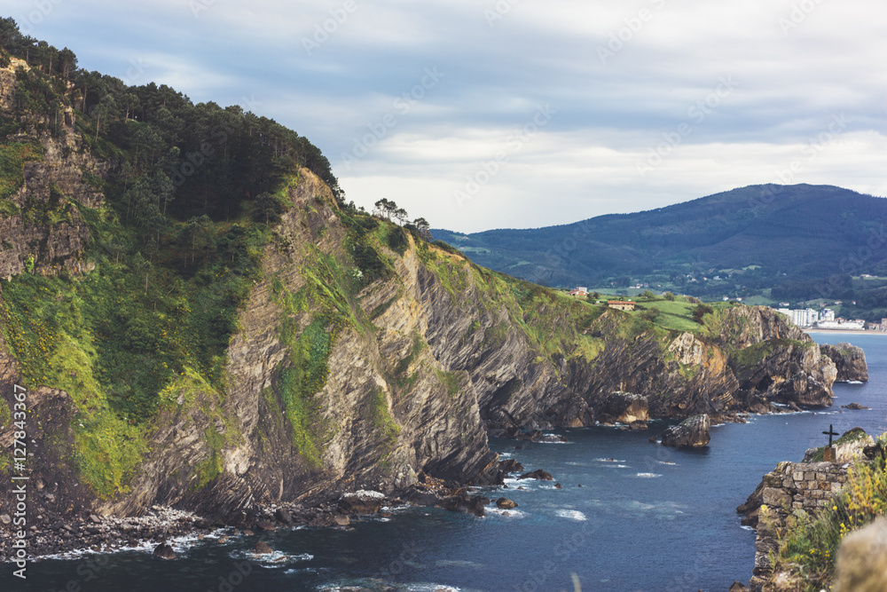 Green valley landscape on background view sunlight ocean in trip holiday in basque island Gaztelugatxe. Panorama horizon of scenery foggy hills Northern Spain alps mountain. Travel mockup