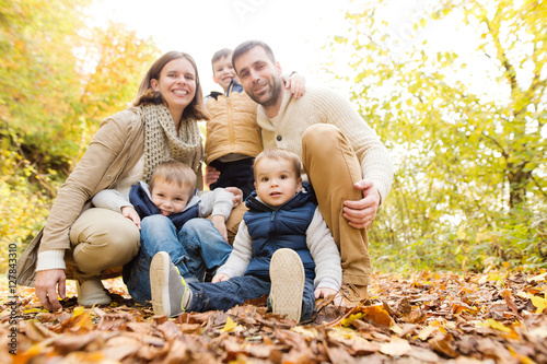 Beautiful young family on a walk in autumn forest.