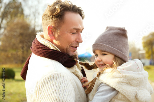 Father and daughter playing in beautiful autumn park