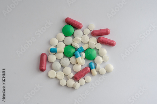 white pills tablets and red capsule green dragee