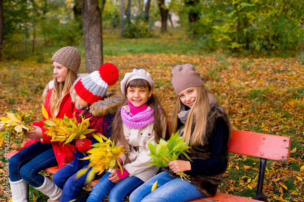 group of girls in autumn park on the brench group of girls in autumn park on the brench