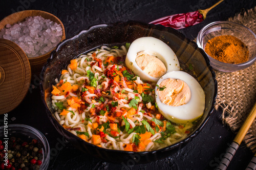 Noodles with egg and spices on a dark background
