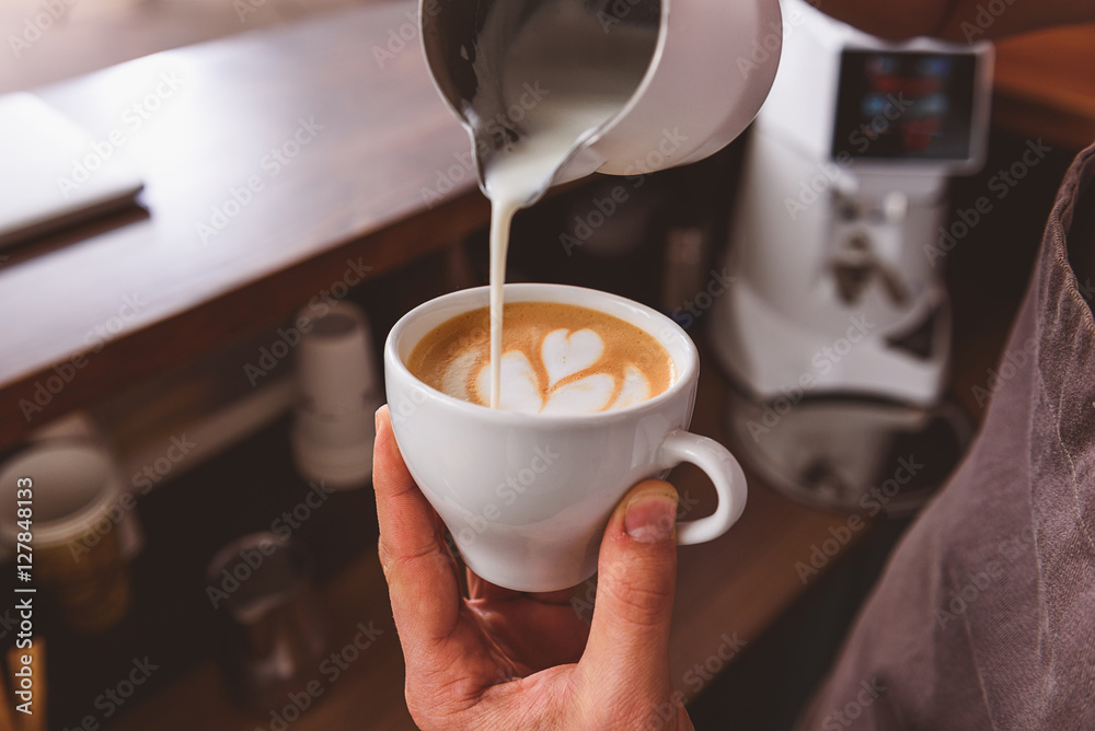 man showing how to make coffee art