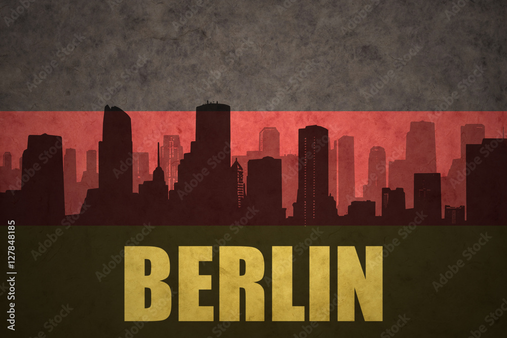 abstract silhouette of the city with text Berlin at the vintage german flag
