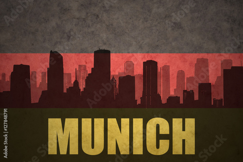 abstract silhouette of the city with text Munich at the vintage german flag