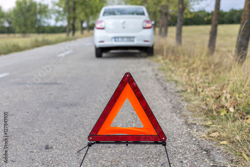  red triangle to warn the other road users about a damaged car