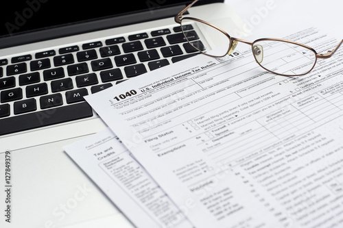 U.S. 1040 income tax return form with laptop and glasses