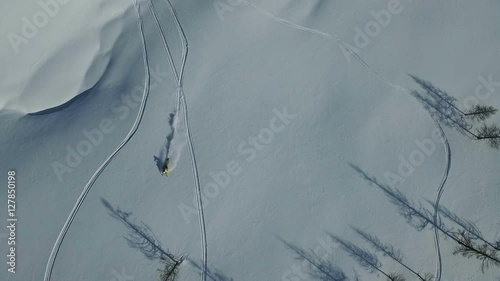 Snowmobiles charges down a mountain in powder snow