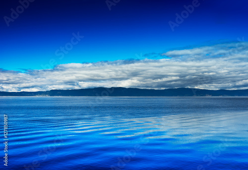 Mountain with clouds on ocean horizon landscape background