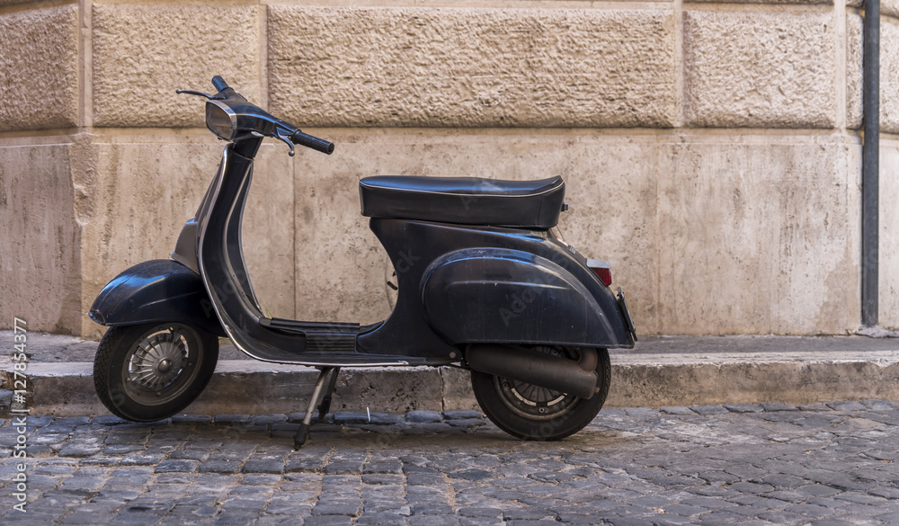 View of vintage scooter against old wall in Rome. Scooter is one of the main transportation means in the Italian capital city.