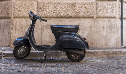 View of vintage scooter against old wall in Rome. Scooter is one of the main transportation means in the Italian capital city.