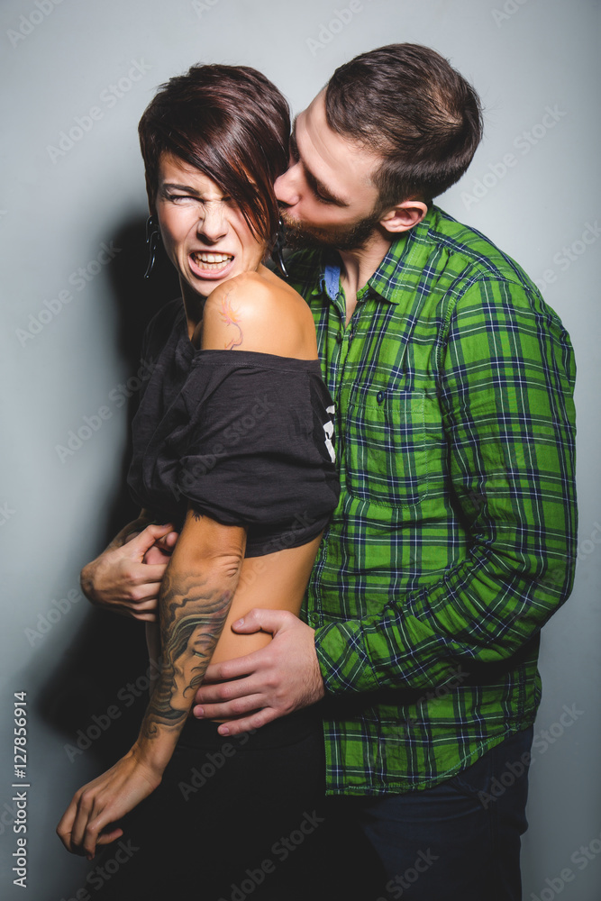 Naklejka premium Beautiful couple hugging and laughing on the tein background. The concept of fun, love and happiness