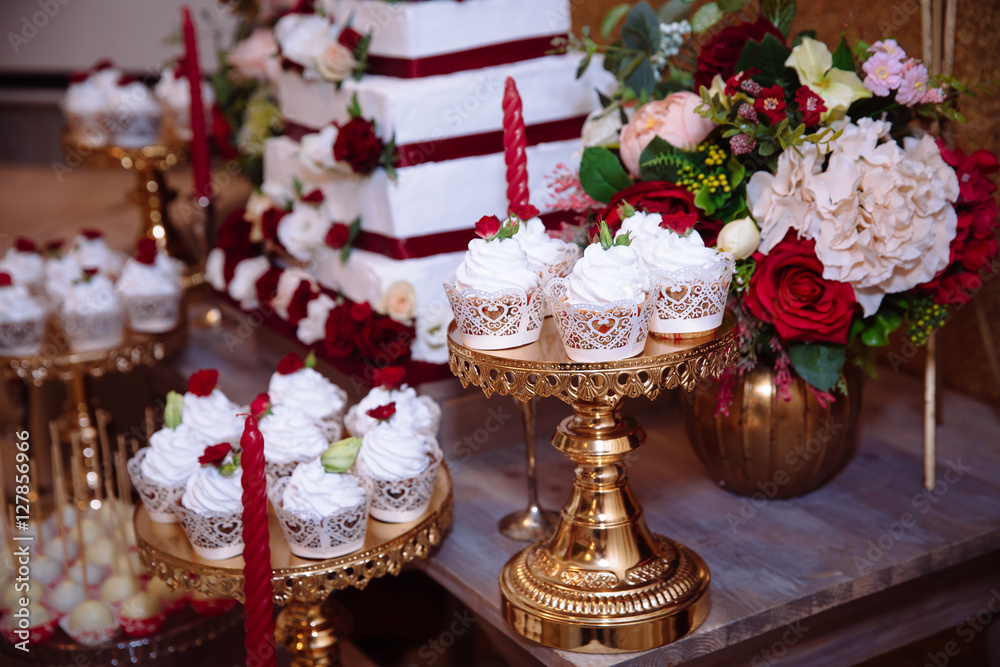 Candy bar, red colour, marsala. Table with wedding cake, sweets, candies, dessert, pops.