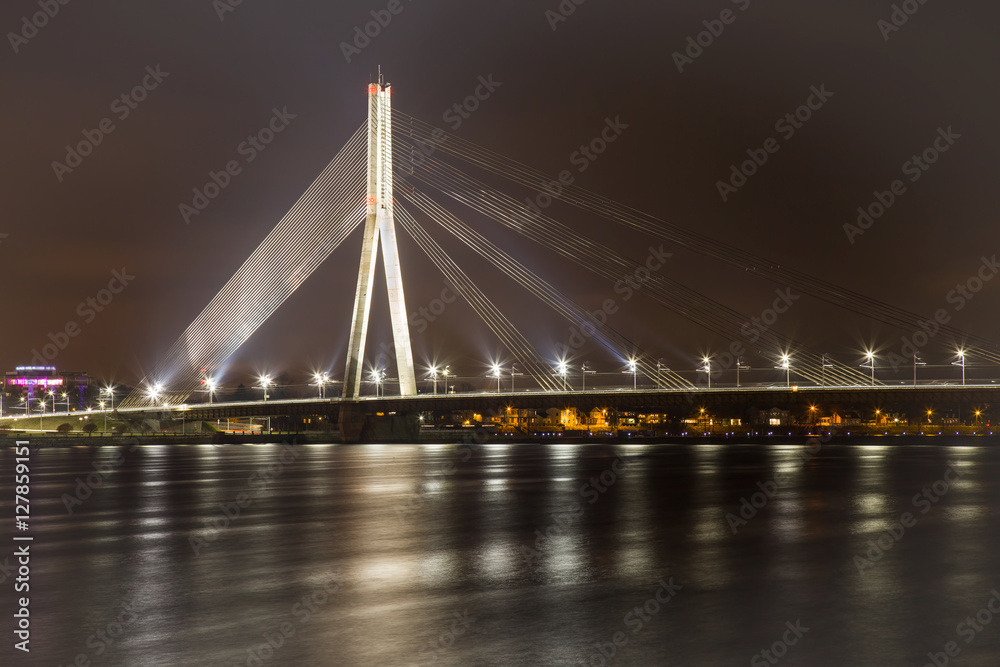 Obraz premium Bridge with white lights across the river in the night. Beautiful lights reflections in the river.