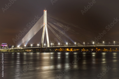Bridge with white lights across the river in the night. Beautiful lights reflections in the river.