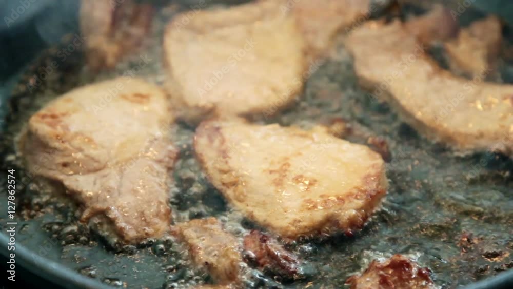 frying chicken with oil splashing all over the place