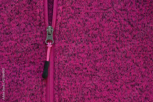 Knitwear in pink melange with zipper. Textured background.