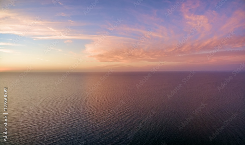 Aerial panoramic view of sunset over ocean. Nothing but sky, clouds and water. Beautiful serene scene