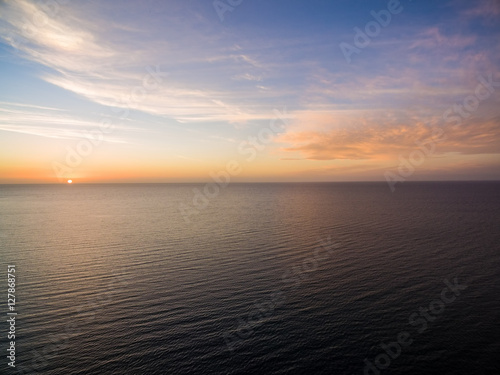 Aerial view of sun setting over ocean. Nothing but skies and water. Beautiful tranquil scene