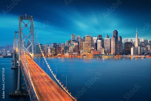 Obraz San Francisco o wschodzie słońca z Bay Bridge na pierwszym planie. Niesamowity widok na słynne miasto Ameryki. Motyw kalifornijski. Fotografia artystyczna.