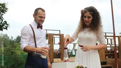 Beautiful couple in turn poured sand into the bottle. Filled with happiness. The sand mix.