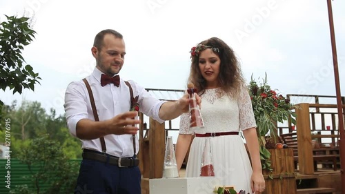 The groom closes the bottle with sand. Wedding tradition sand mix.
