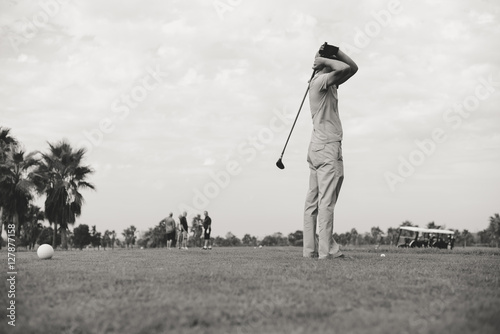 Canvas Print Retro vintage image rear view of male golfer holding wooden golf club, green fie