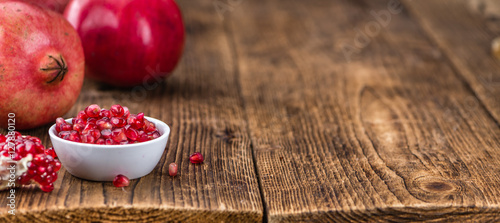 Pomegranate seeds on wooden background (selective focus)