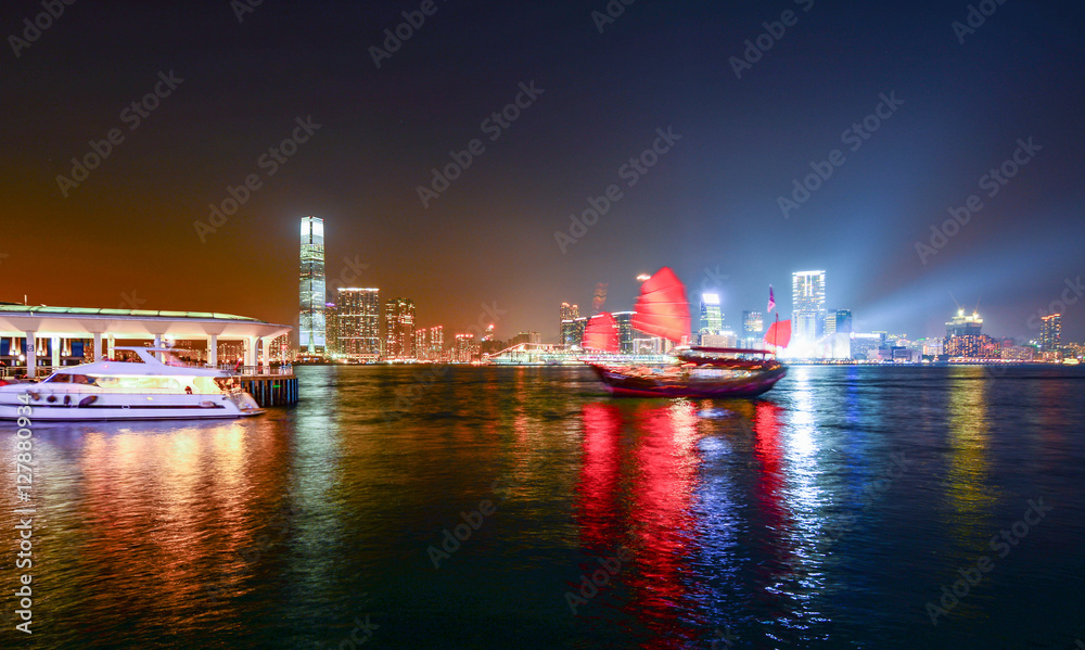 Hong Kong skyscrapers at night with boats in movement