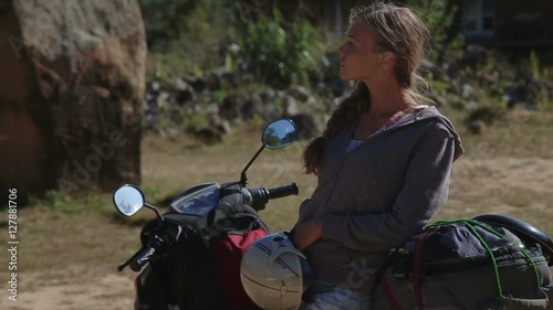 Young beautiful girl sitting on scooter mountain road photo