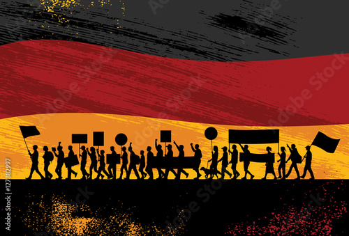 Silhouette of people protesting with flag of Germany as a background