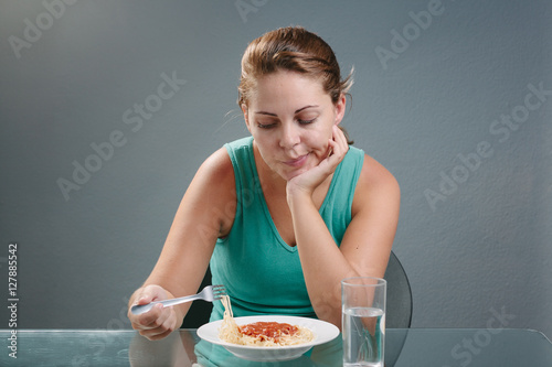 Portrait of woman with no appetite in front of the meal. Concept of loss of appetite