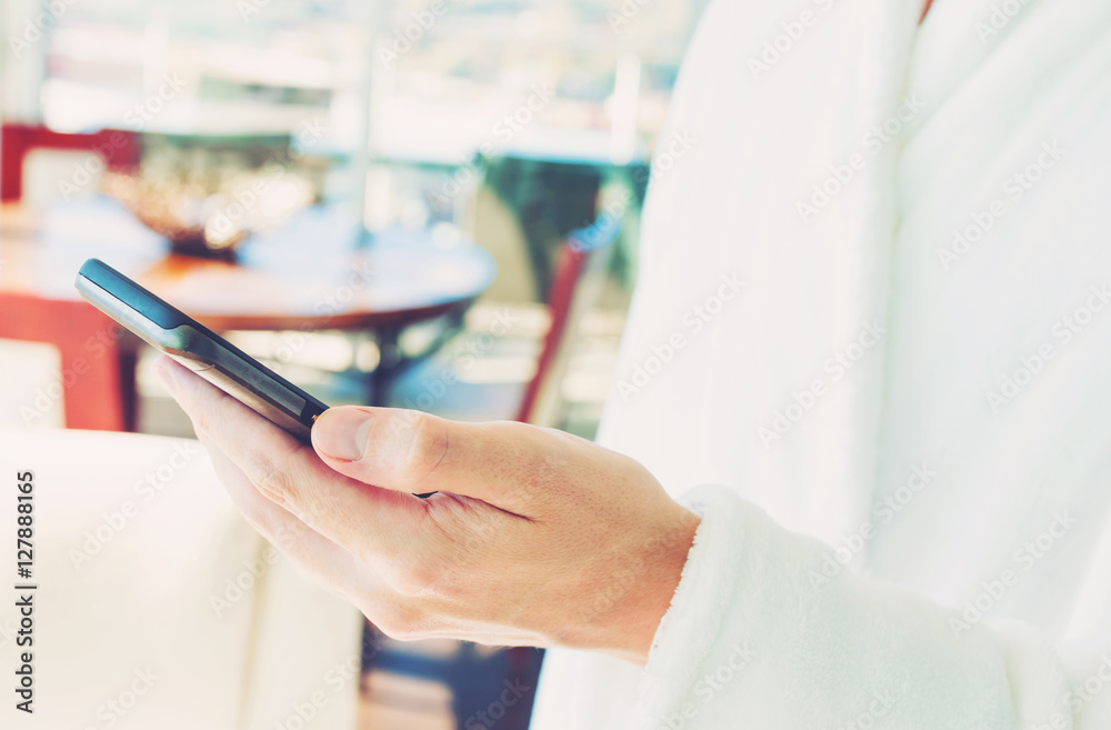 Man in a bathrobe using his smartphone Man in a bathrobe using his smartphone